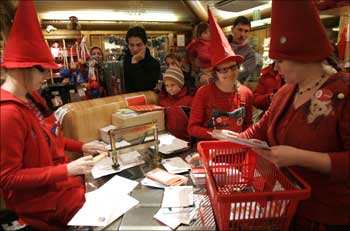 People dressed as elves post mark letters with the stamp from Santa Claus' Post Office on the Arctic Circle near Rovaniemi, northern Finland.