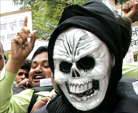An Indian trader wears a mask during a protest against the Value Added Tax (VAT), in New Delhi.