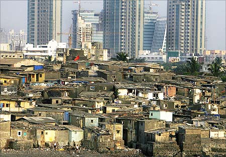 High rise buildings are seen behind a slum in Mumbai.