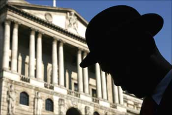 An actor is silhouetted in front of the Bank of England during the filming of a TV programme.